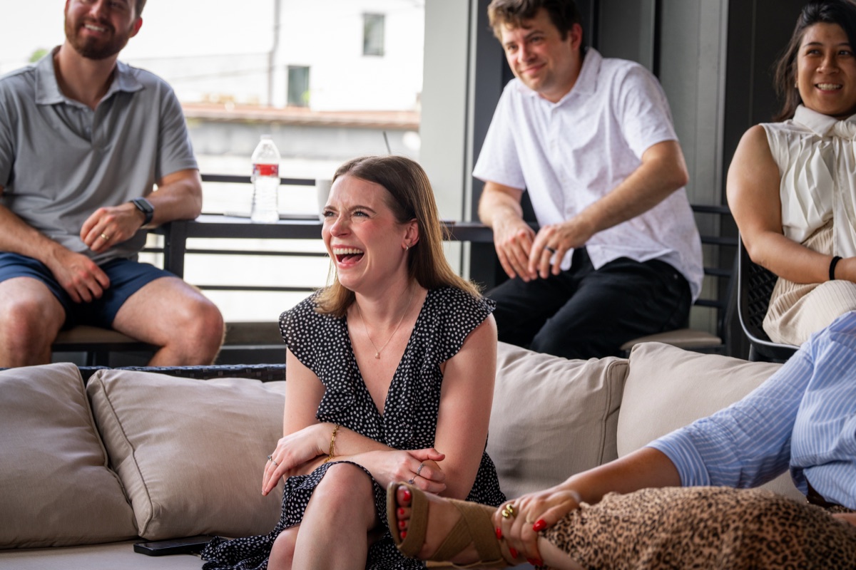 Team members talking and laughing on a couch